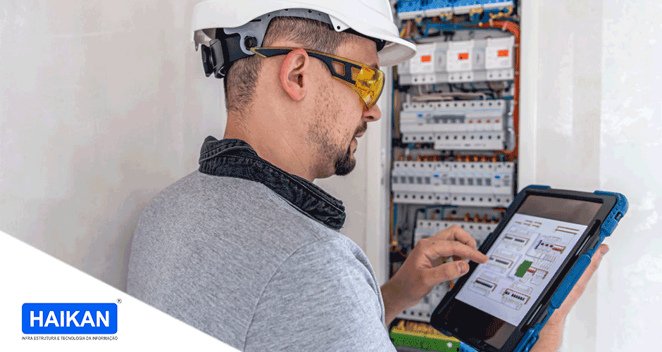 Um homem usando capacete e óculos segurando um tablet